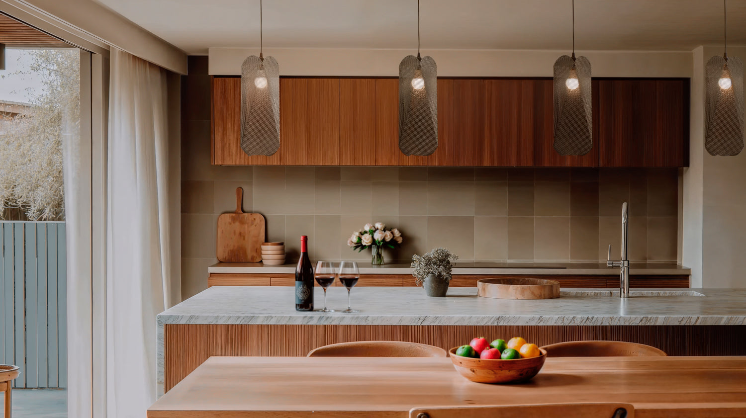 Modern kitchen with wooden cabinets, pendant lights designed by David Trubridge